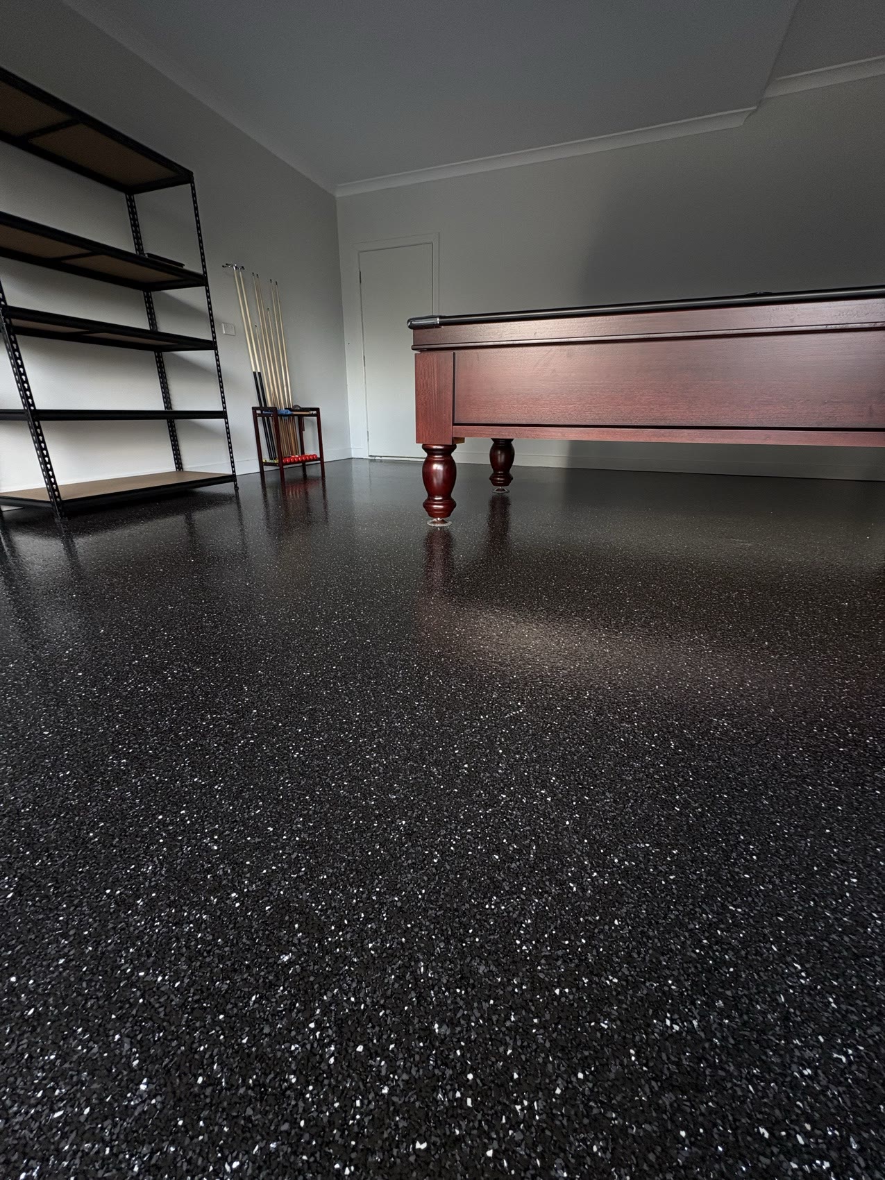 Carbon black epoxy flake floor in a games room with a pool table