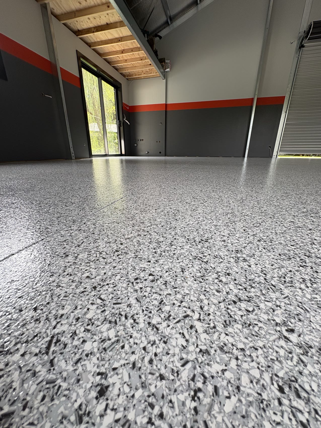 Residential shed with grey epoxy flake flooring and a red feature stripe